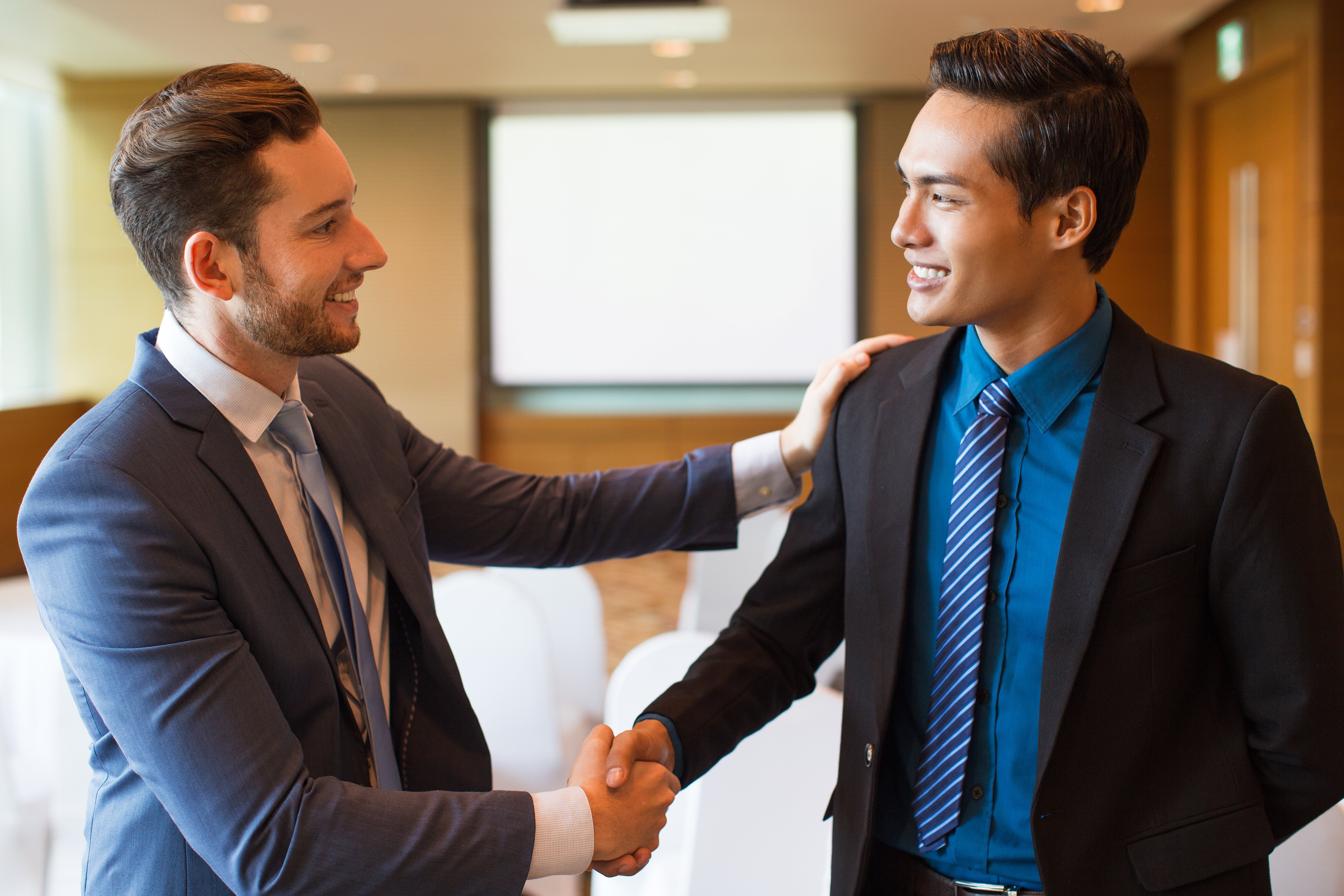 Malaysian business leader congratulating a newly hired employee through direct placement recruitment, symbolising successful talent acquisition